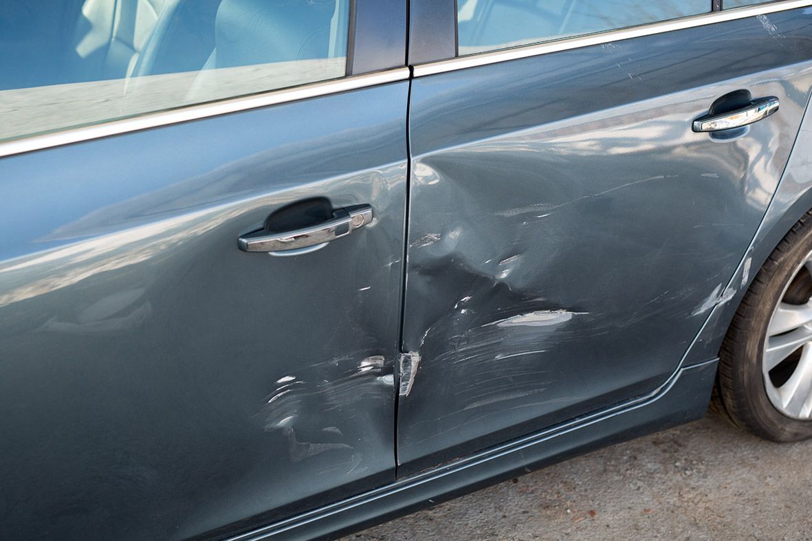 Haftpflichtschaden: Seitenansicht einer demolierten Tür nach Autounfall