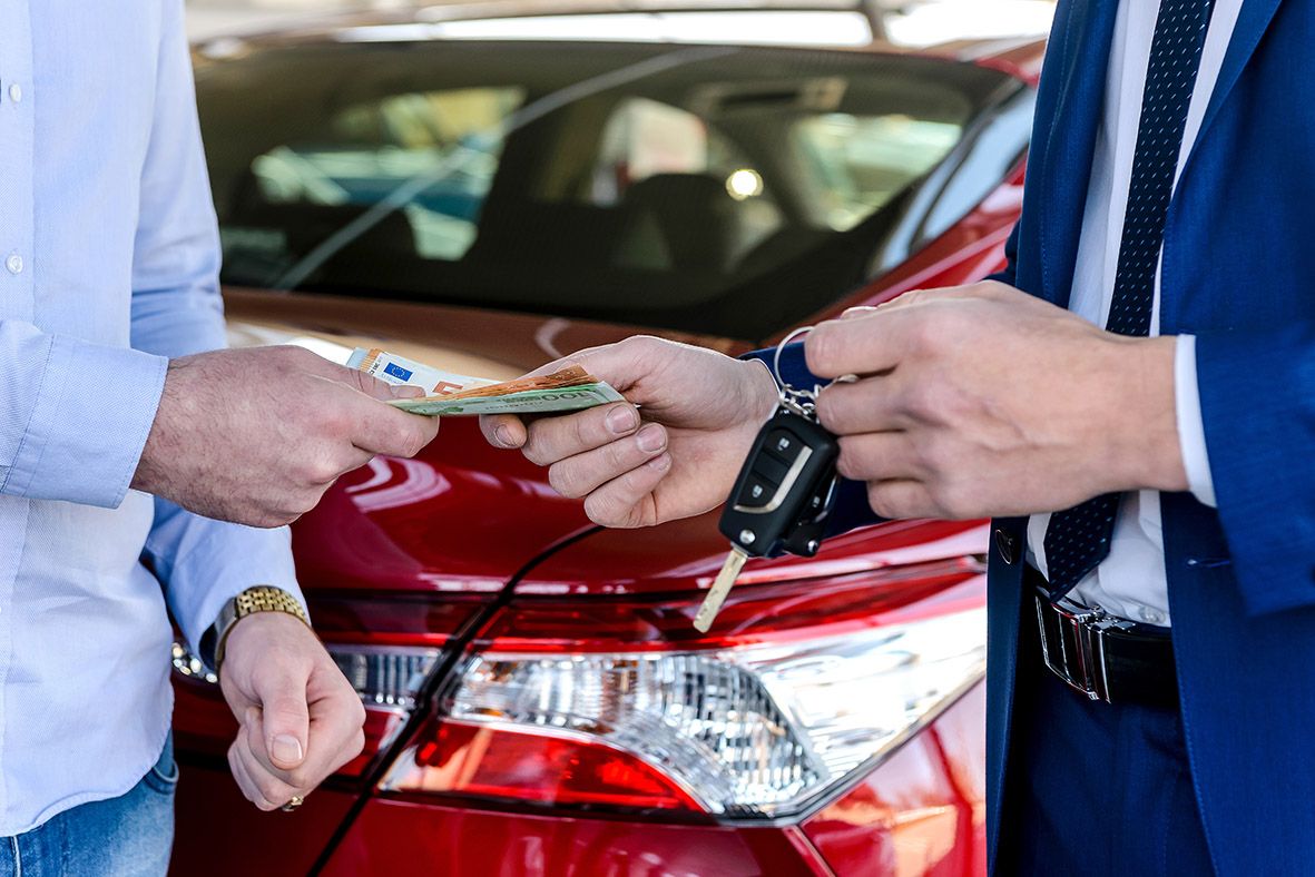 Geld- und Autoschlüsselübergabe nach erfolgreichem Fahrzeugverkauf